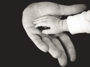 Baby hand holding an adult's hand