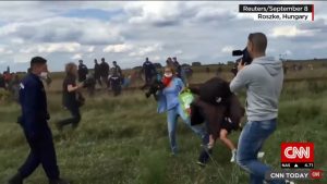 picture of camerawoman tripping up a fleeing refugee