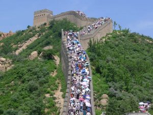 Tourists on the Great Wall of China using umbrellas to protect themselves from the burning sun
