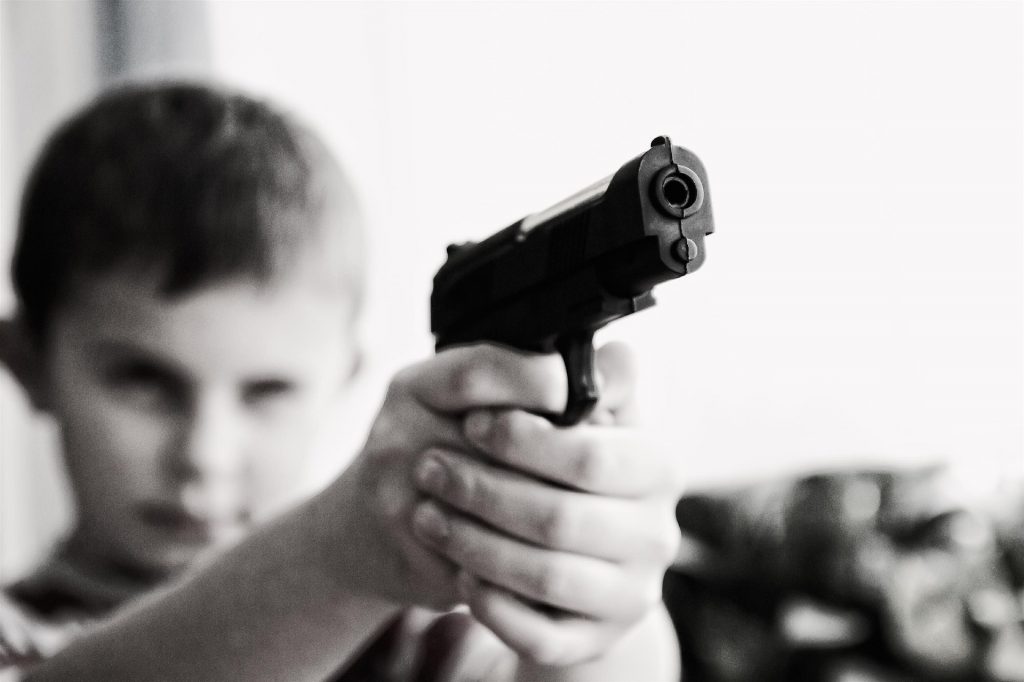 Child holding and aiming pistol 