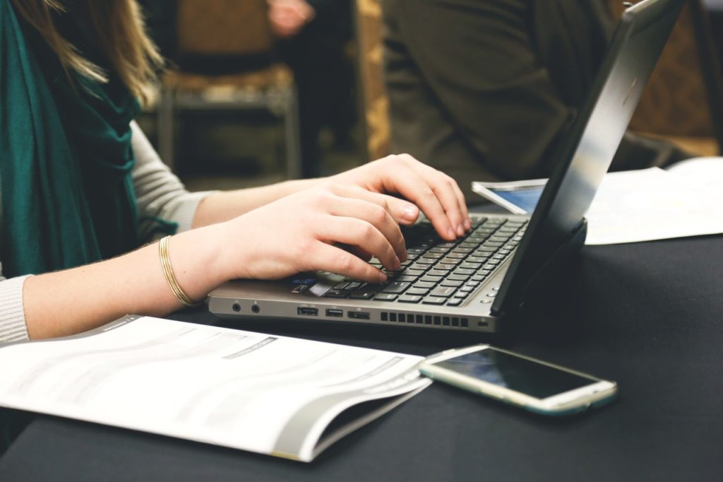 Photo of person writing on a laptop