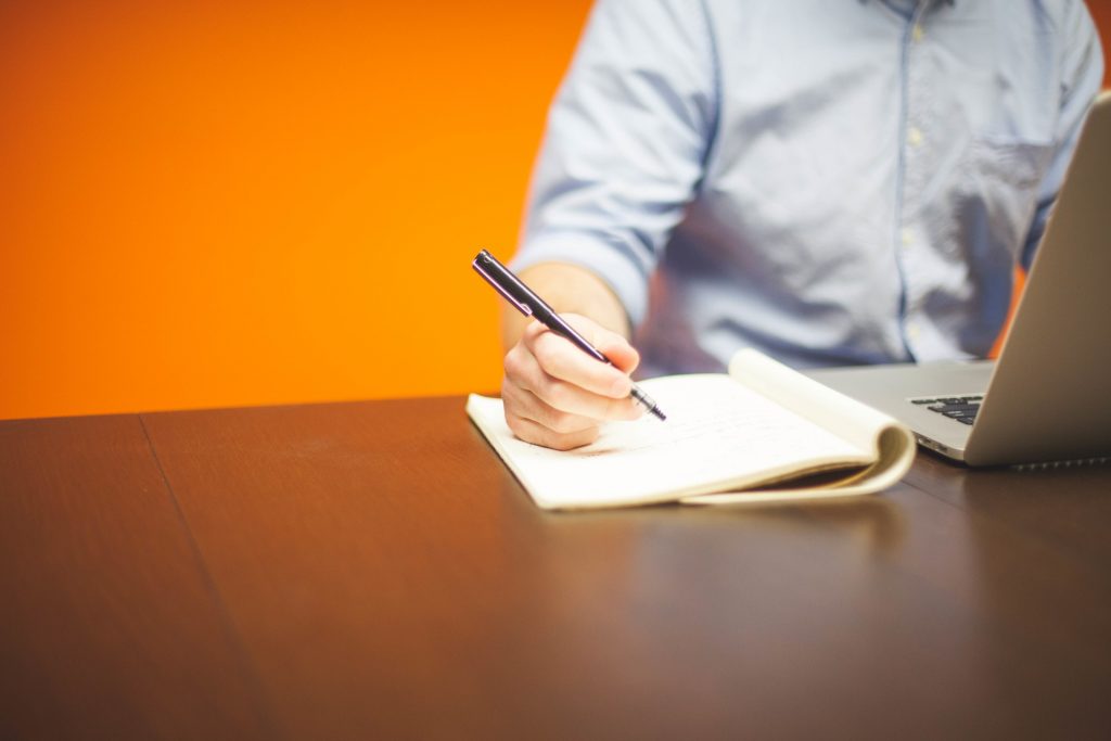 Photo of man writing at computer